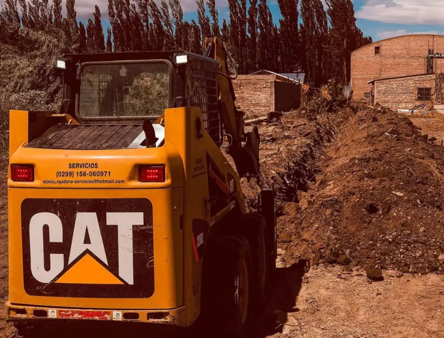 Minicargadora trabajando junto a una zanja