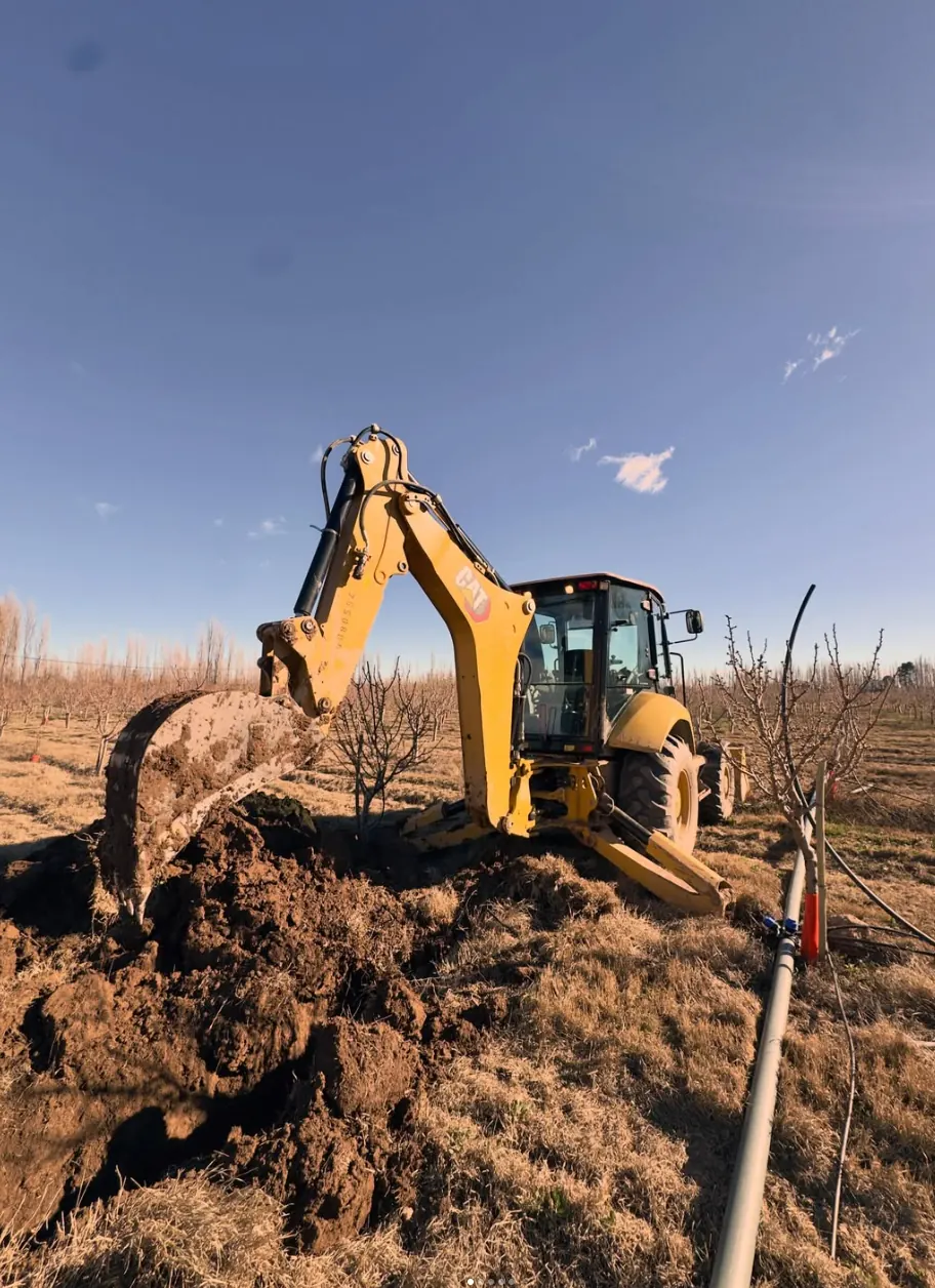 Retroexcavadora excavando en una chacra del Alto Valle